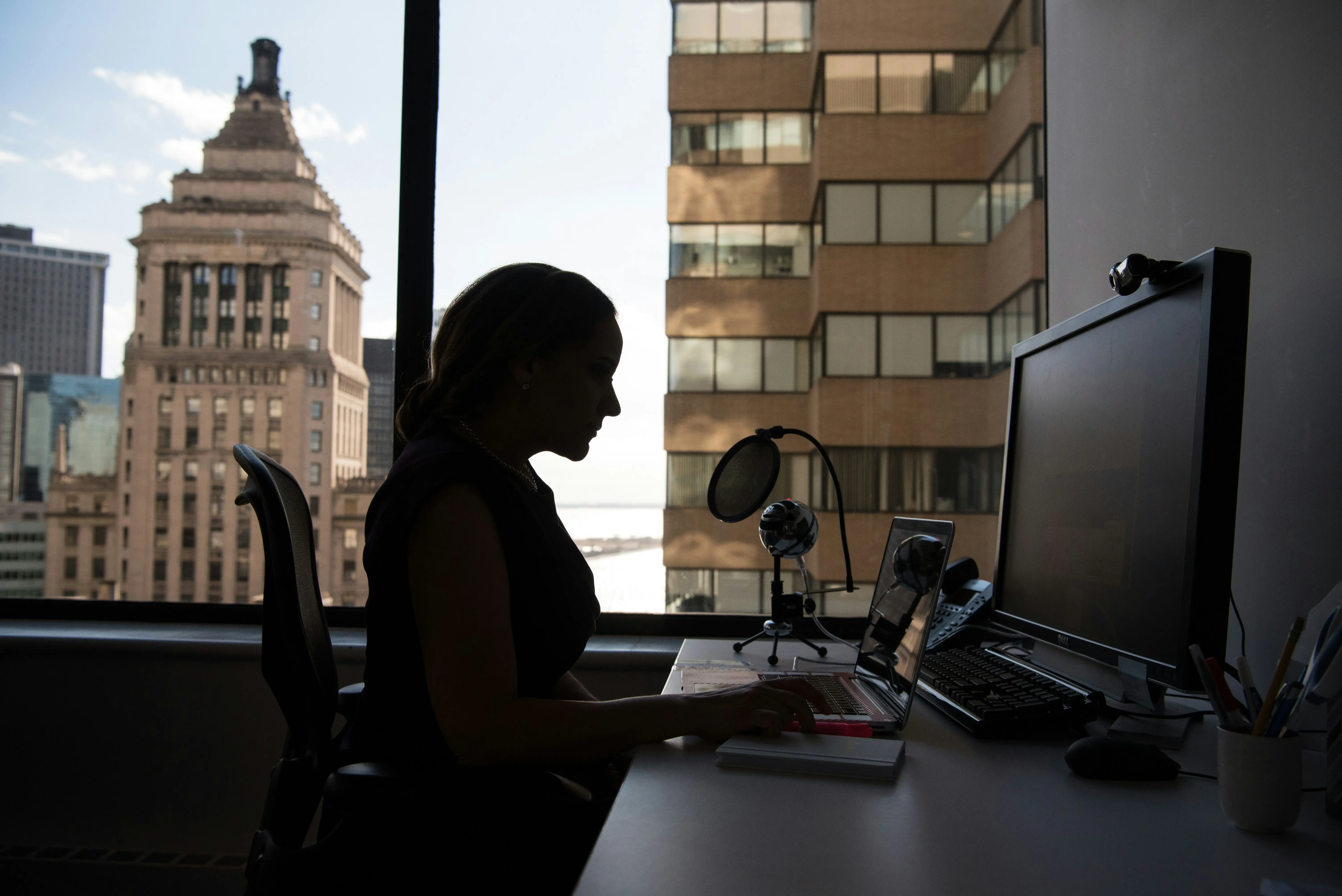 Frau in einem Büro am Schreibtisch, vor ihr ein Laptop
